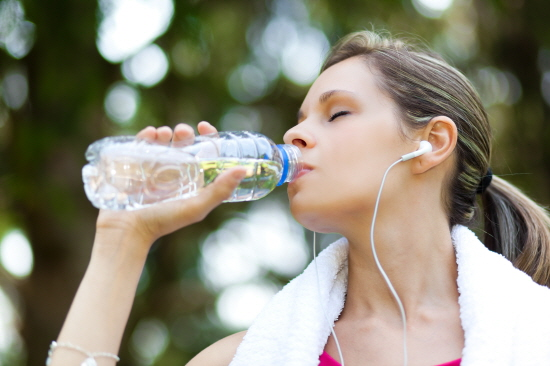 Una mujer haciendo ejercicio y tomando agua embotellada para la prevención de la obesidad y un estilo de vida saludable